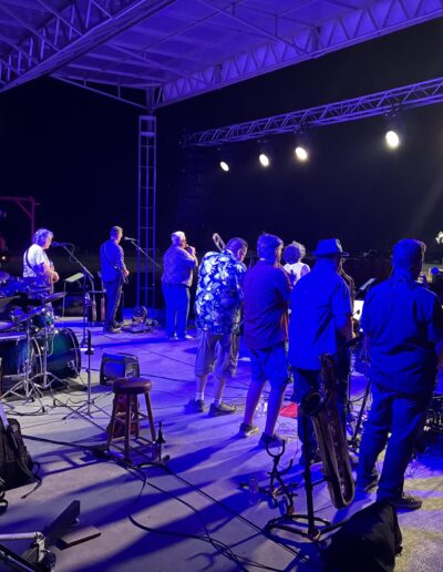 A band performing on the main stage under blue lights at night