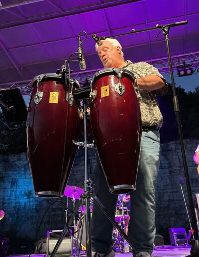 A percussionist playing conga drums on the night stage