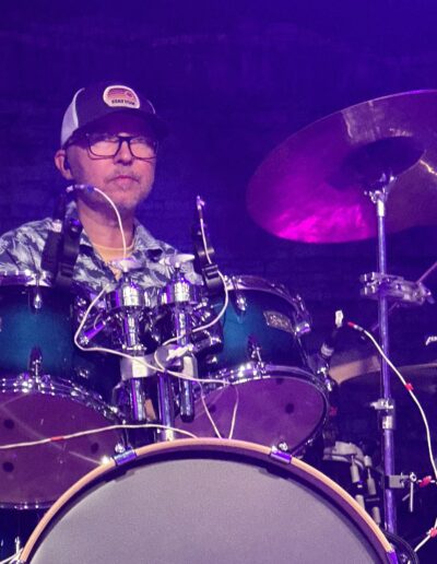 A drummer playing under the night stage lights