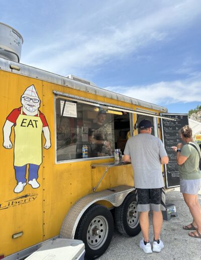 Guests ordering at a food trailer on a sunny afternoon