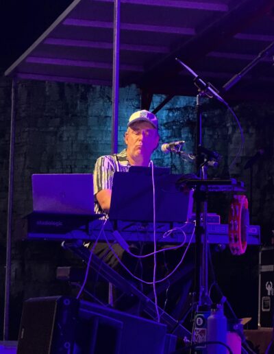 A keyboard player at a laptop and keyboard rig during the night set