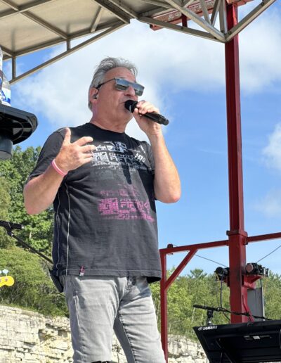 A lead singer performing on the main stage in the afternoon