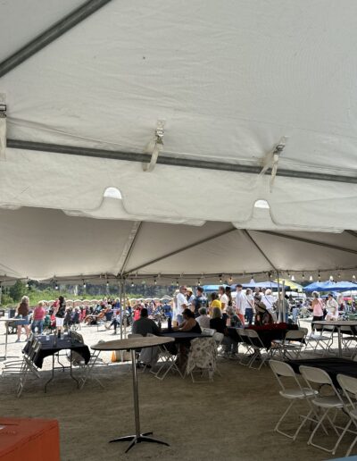Guests at tables under the big tent with the grounds beyond